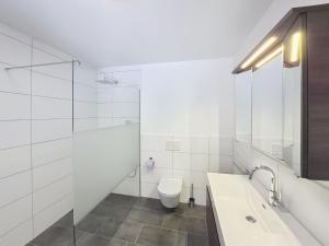 a white bathroom with a toilet and a sink at Apartment Halbeis by Interhome in Matrei am Brenner
