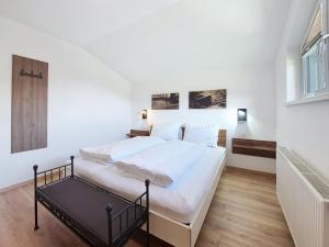 a white bedroom with a large bed with white sheets at Apartment Halbeis by Interhome in Matrei am Brenner