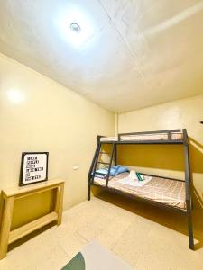 a room with a bunk bed and a sign on the ceiling at Maru Vibe Guesthouse V2 in San Juan