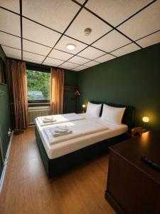 ein Schlafzimmer mit einem großen Bett in einem grünen Zimmer in der Unterkunft Vintage HOTEL S-Weilimdorf in Stuttgart-Weilimdorf
