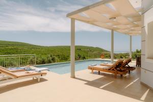 a patio with chairs and a swimming pool at Villa Guesto with Private Pool by MindYourVilla in Anafonítria