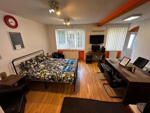 a room with a bed and a table and a desk at LUMON Ultra Central Apartman in Târgu-Mureş