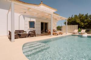 a villa with a swimming pool and a pergola at Villa Guesto with Private Pool by MindYourVilla in Anafonítria