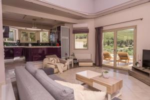 a living room with a couch and a table at Villa Guesto with Private Pool by MindYourVilla in Anafonítria