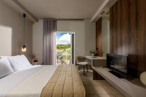 a hotel room with a bed and a television at Louloudis Boutique Hotel in Skala Rachoniou