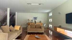 a living room with a couch and a tv at Moradia Lux RR com piscina in Penafiel +18 photos