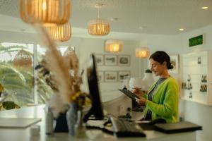 a woman sitting at a desk with a computer at Le Cardinal - Belle-Ile-en-Mer in Sauzon +63 photos