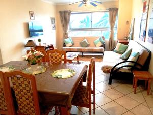 a living room with a table and a couch at Beach Retreat in Amanzimtoti