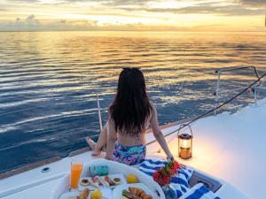 a woman sitting on a boat with a plate of food at Palau Mangrove Hotel in Koror +94 photos