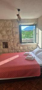 a bedroom with a red bed with a window at Apartmani Furesti1 in Donji Stoliv +5 photos