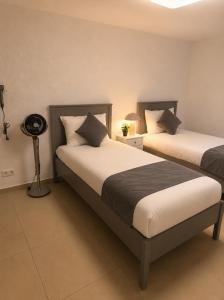 a bedroom with two beds and a lamp at NEU! Fly & Stay Residence Frankfurt Airport Kelsterbach in Kelsterbach