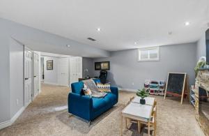 a living room with a blue couch and a table at Cozy Kitchener-Waterloo Home in Kitchener