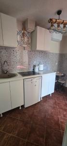 a kitchen with white cabinets and a sink at Apartmani Furesti1 in Donji Stoliv