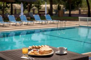 a plate of food on a table next to a pool at Apollo Hotel in Laganas