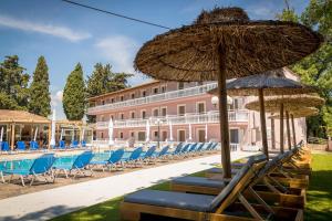a group of chairs and umbrellas next to a pool at Apollo Hotel in Laganas