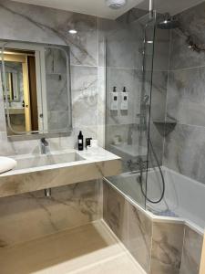 a bathroom with a shower and a sink and a tub at Hostellerie du Royallieu in Compiègne +14 photos