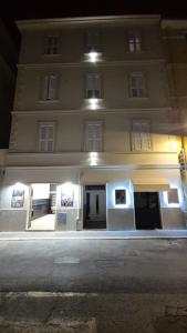 a large white building with paintings on it at night at Anzio Central Apartments in Anzio