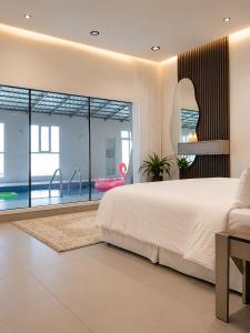 a bedroom with a large bed and a large window at استراحة الوداد in Qurayyah
