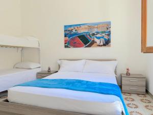 a bedroom with a bed and a painting on the wall at Baia Verde - Dimitri House in Baia Verde