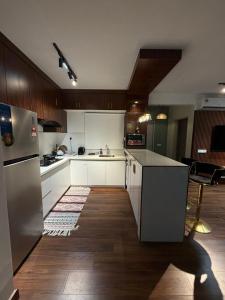 a kitchen with white cabinets and a stainless steel refrigerator at The Amour Suite in Teluk Panglima Garang