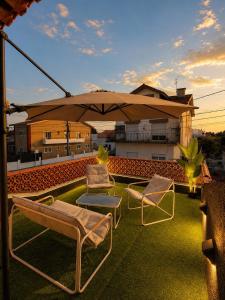 a patio with two chairs and an umbrella on a roof at Villa Salgado in Gafanha da Nazaré