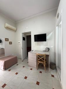 a bedroom with a desk and a bed and a tv at Donna Vicenza Bed & Breakfast in Naples