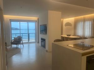 a kitchen and living room with a view of the ocean at Beachfront 3bdr apt on Marginal Boulevard in São Martinho do Porto