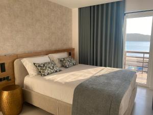 a bedroom with a bed with a view of the ocean at Beachfront 3bdr apt on Marginal Boulevard in São Martinho do Porto