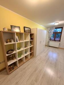 a room with white shelves and a yellow wall at Rose & Vintage Mansard in Kuldīga