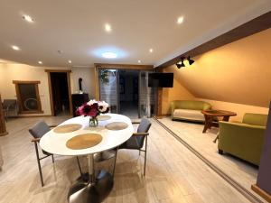 a living room with a white table and chairs at Rose & Vintage Mansard in Kuldīga