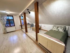 a bedroom with a bed and a desk in a room at Rose & Vintage Mansard in Kuldīga