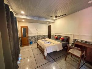a bedroom with a bed and a piano at Hope Hostels - Munnar in Munnar