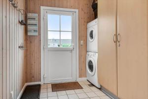 a laundry room with a door and a washing machine at C11653-Hemmet-Ranunkelvaenget-4 in Hemmet