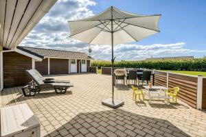 a patio with an umbrella and a table and chairs at C11653-Hemmet-Ranunkelvaenget-4 in Hemmet