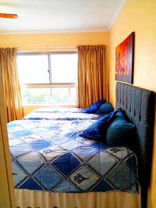 a bedroom with a bed and a window at Beach Retreat in Amanzimtoti +26 photos