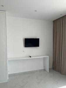 a white room with a tv on a white wall at Break Room Dea in Draç