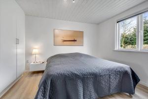a white bedroom with a bed and a window at C11629-Hemmet-Ildervej-10 in Hemmet