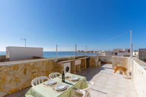 a patio with a table and chairs and the ocean at A due passi dal Mare in Torre Lapillo