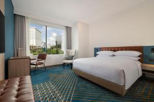a hotel room with a bed and a desk and chair at Four Points by Sheraton Jakarta Thamrin in Jakarta