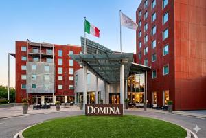 a sign in front of a building with two flags at Domina Milano Fiera in Novate Milanese