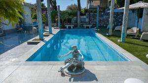 a statue of a woman on a turtle in a swimming pool at Luxury suite Portorož in Portorož