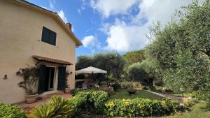 a house with a yard with a patio and trees at Villa Matilda ad Ansedonia in Orbetello