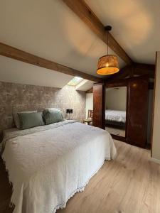 a bedroom with a white bed and a mirror at Gîte La Vielle Forge in Virazeil