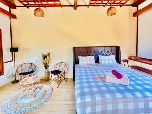a bedroom with a bed and two chairs and a table at Omah Osing Ijen Banyuwangi in Licin