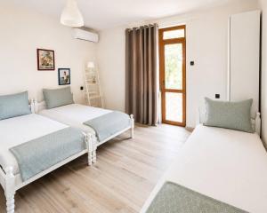 a bedroom with two beds and a window at Нашата къща in Sinemorets