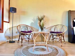 three rattan chairs and a table and a lamp at Omah Osing Ijen Banyuwangi in Licin