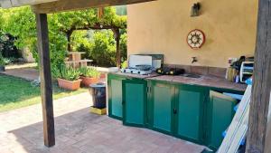 an outdoor kitchen with a green island in a yard at Villa Matilda ad Ansedonia in Orbetello