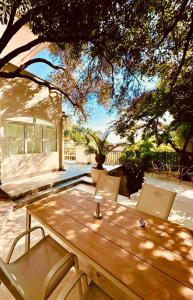 a wooden table and chairs under a tree at Villa Nemanja in Sveti Stefan