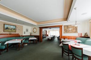 a dining room with tables and green chairs at Komorni Hurka in Cheb