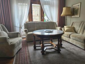 a living room with a coffee table and couches at Bed & Breakfast - Haus Hubertus in Brauneberg +5 photos